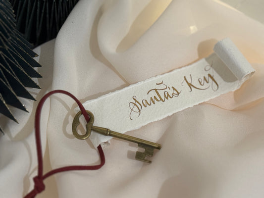 Decorative key with 'Santa's Key' label on a white surface