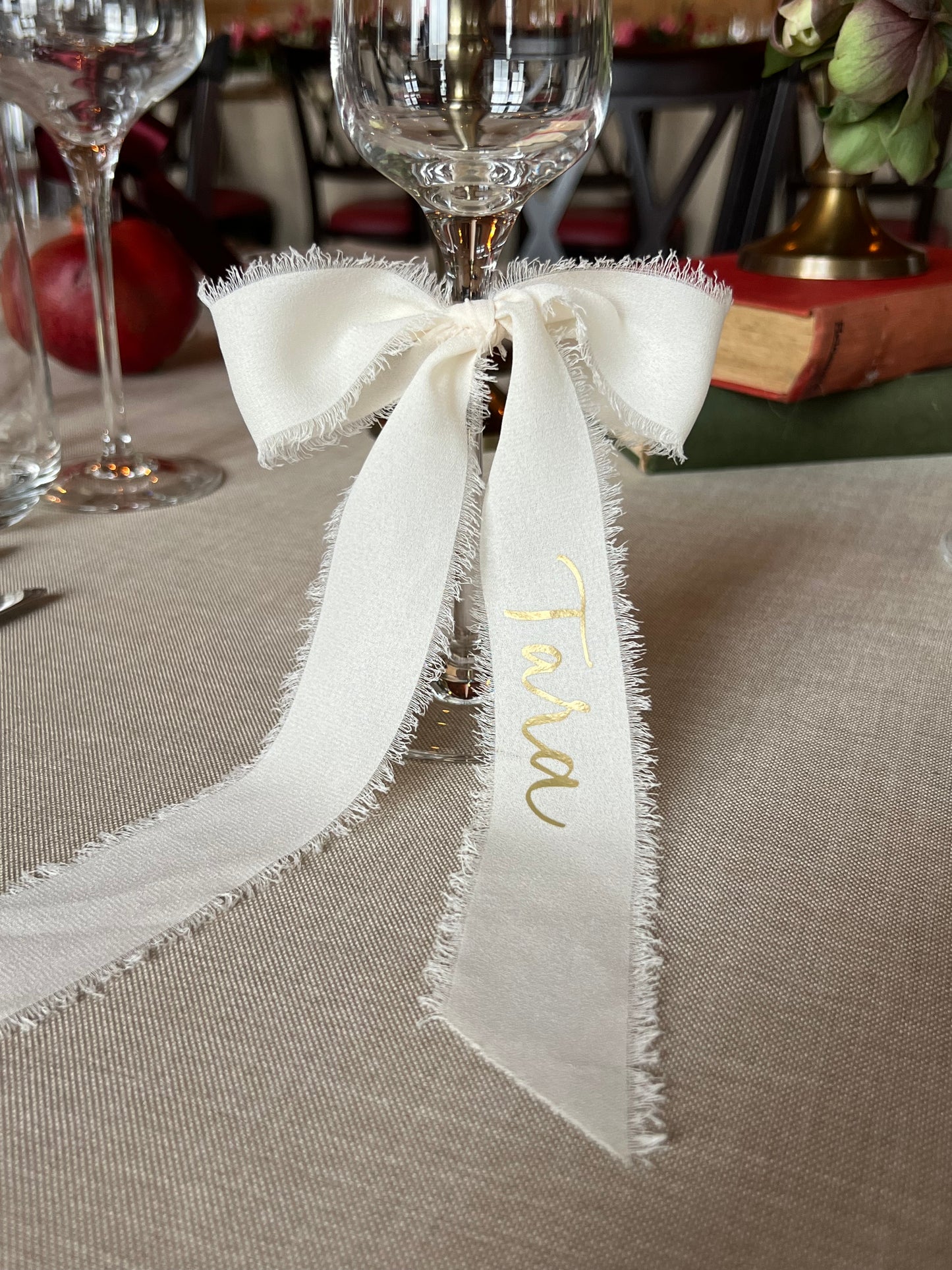 White fabric ribbon bow with gold calligraphy name