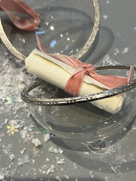 open glass bauble with scroll inside tied with velvet ribbon