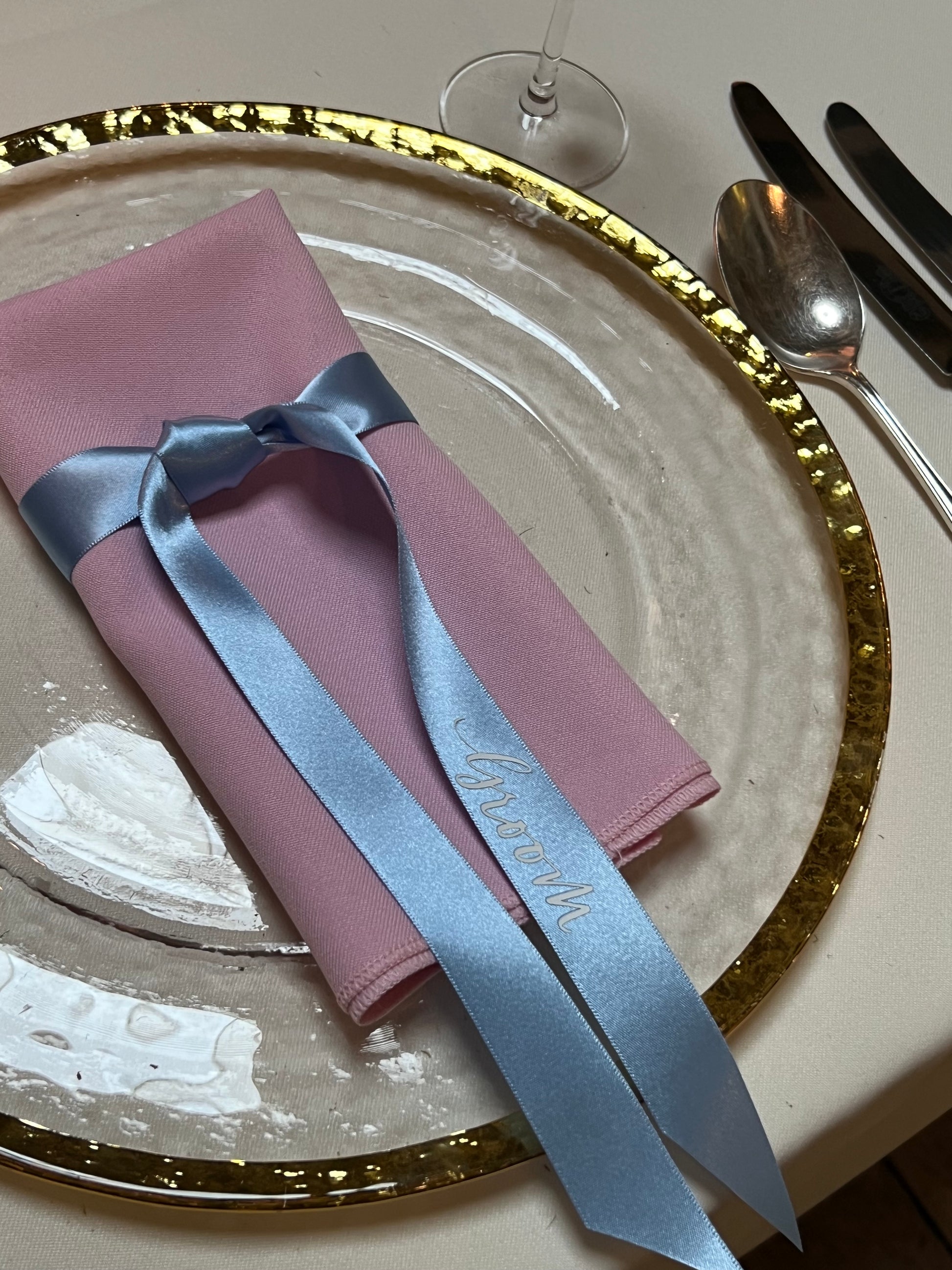 Blue ribbon tired around napkin on a plate