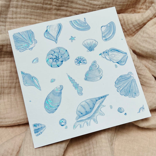 shimmering greetings card with lots of blue shells and sparkling with glitter.