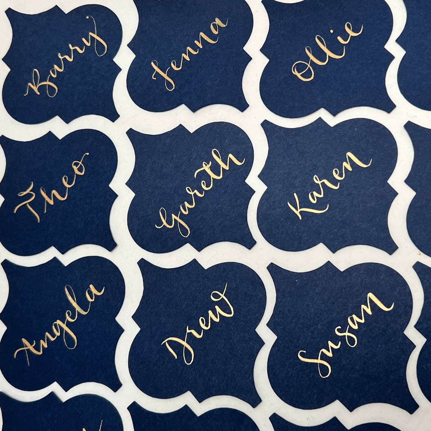 rows of moroccan tile shape cards with gold ink names