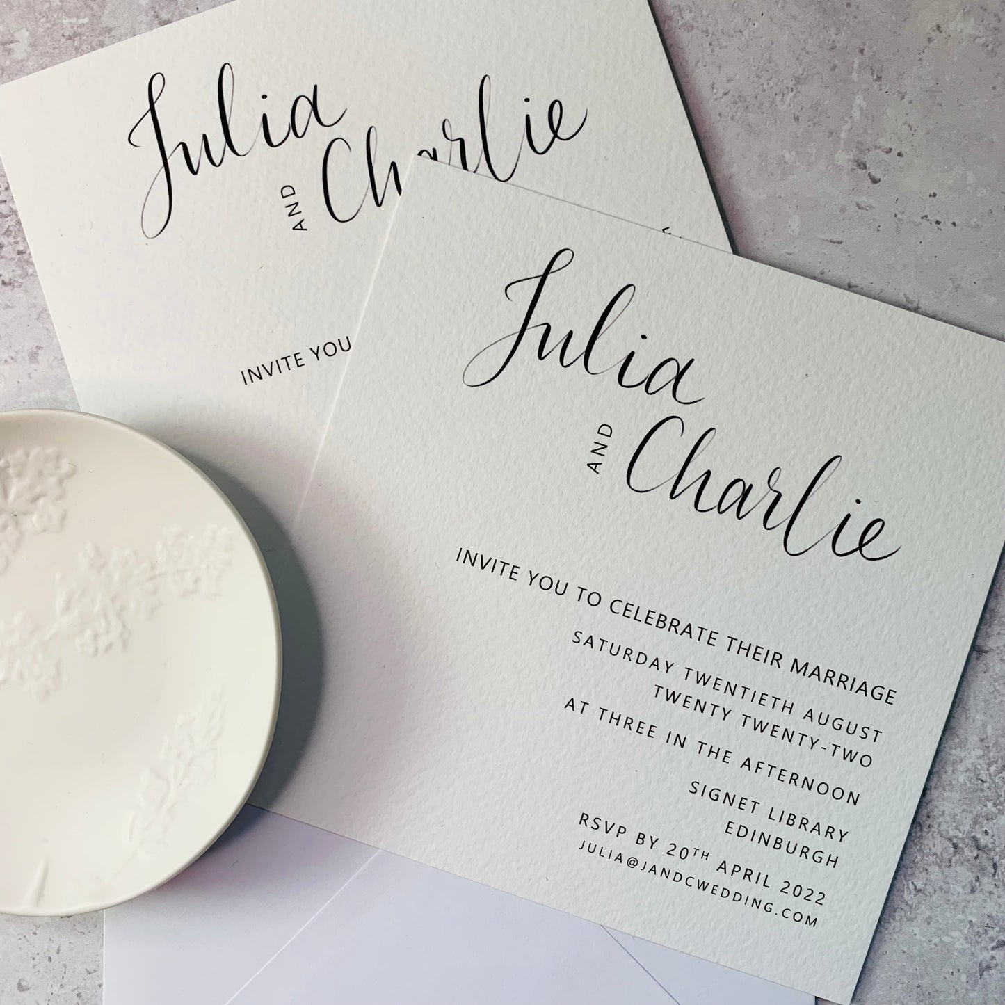 Black and white calligraphy invites on marble background