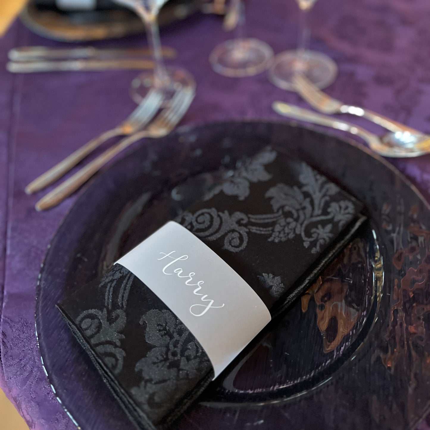 guest name cuff around napkin white ink on black linen