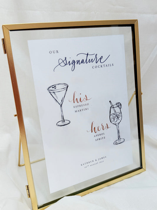 Framed sign with signature cocktails for a couple's names on a white background