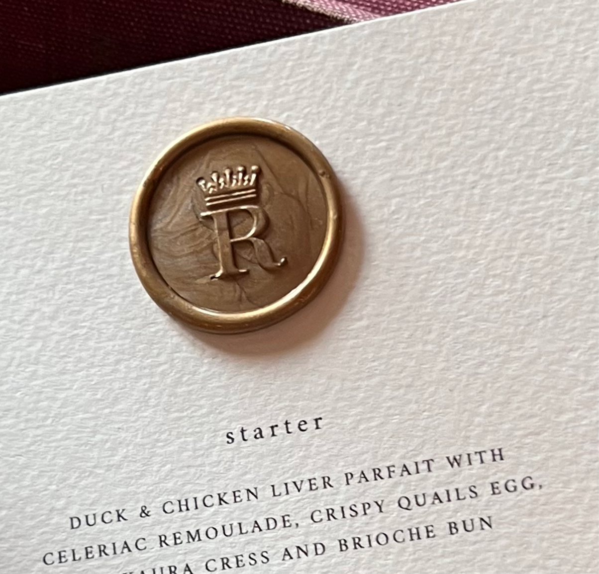 Gold personalised initial wax seal on paper