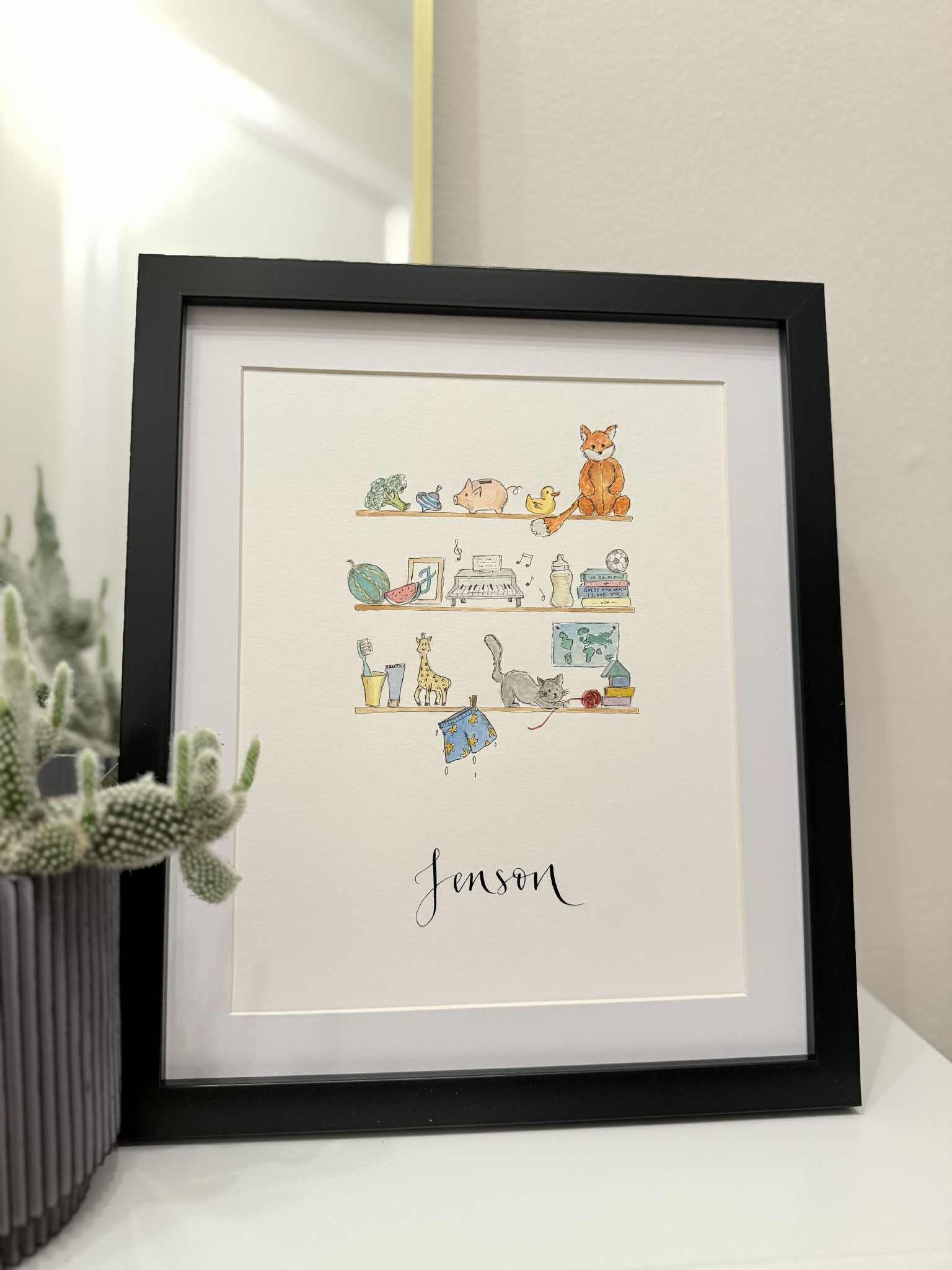 Framed illustration of children's books with animals on a shelf, signed 'Jenson', against a neutral background.