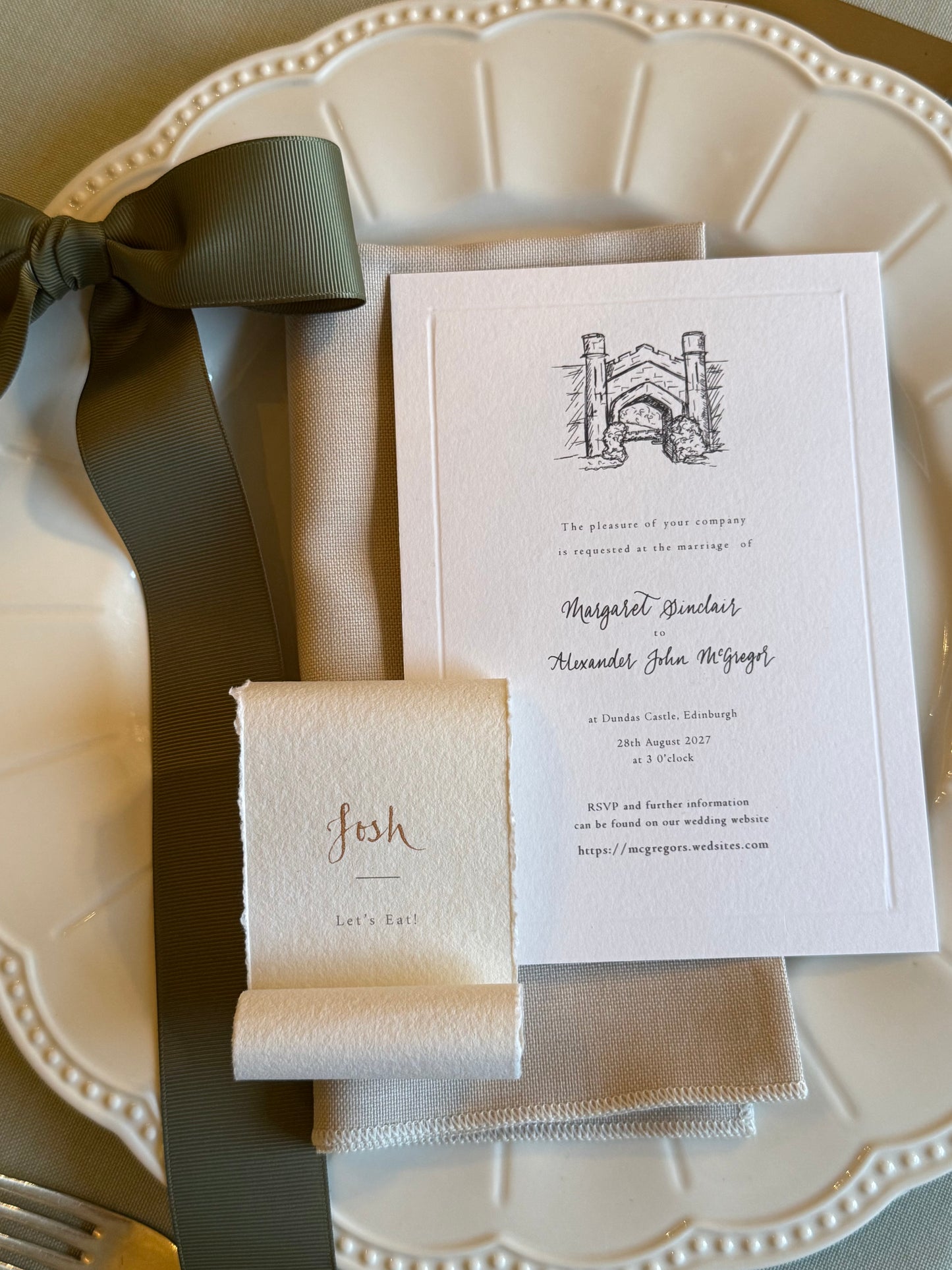 Wedding invitation with a bow on a decorative plate with guest name scroll