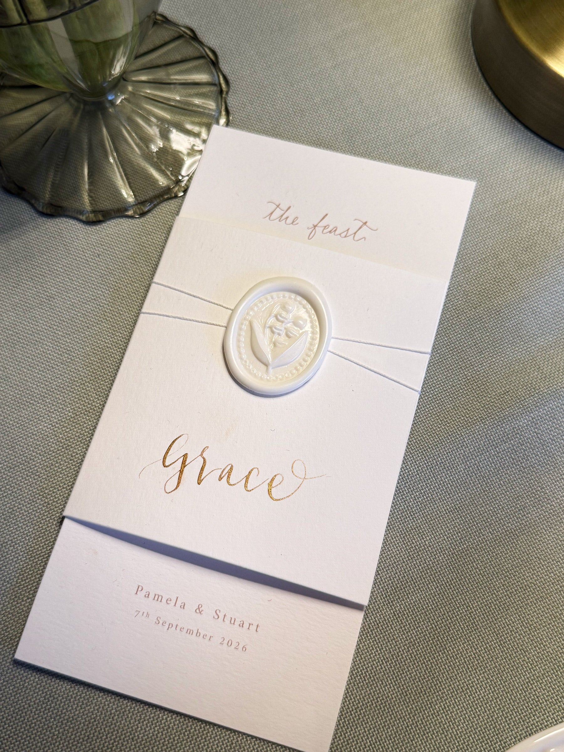 Invitation card with a decorative emblem on a textured surface