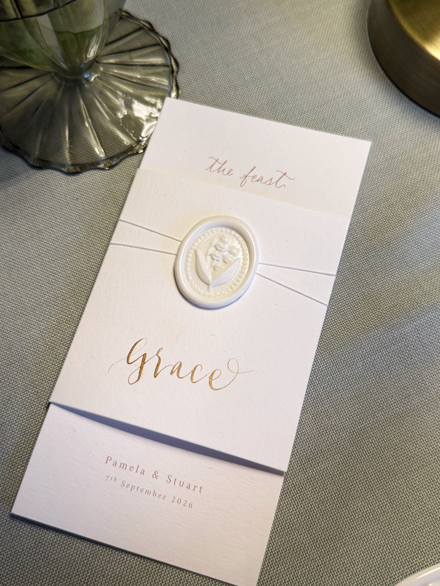Invitation card with a decorative emblem on a textured surface