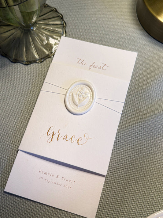 Invitation card with a decorative emblem on a textured surface