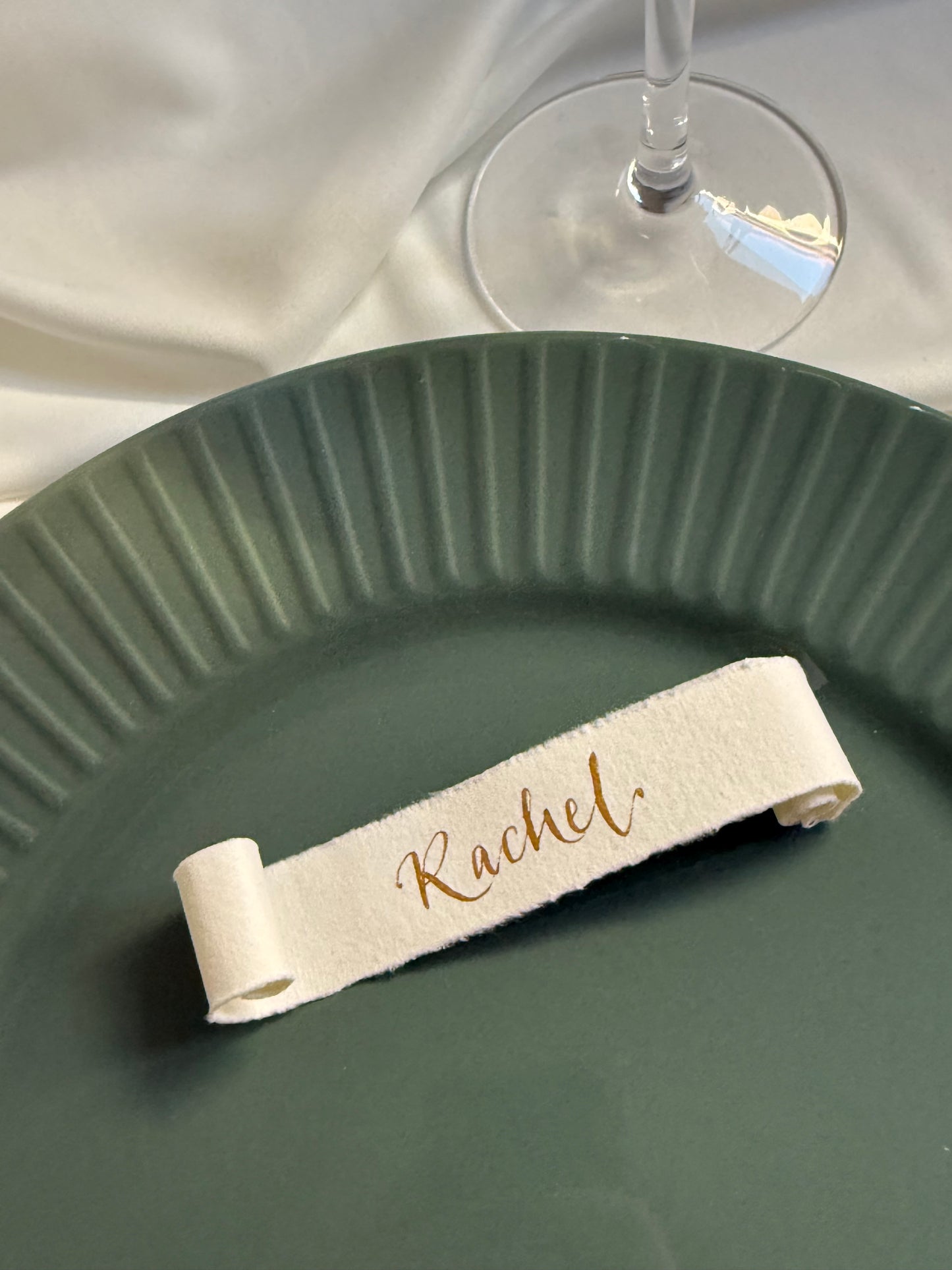 Wine glass with a decorative handwritten name tag on a green plate