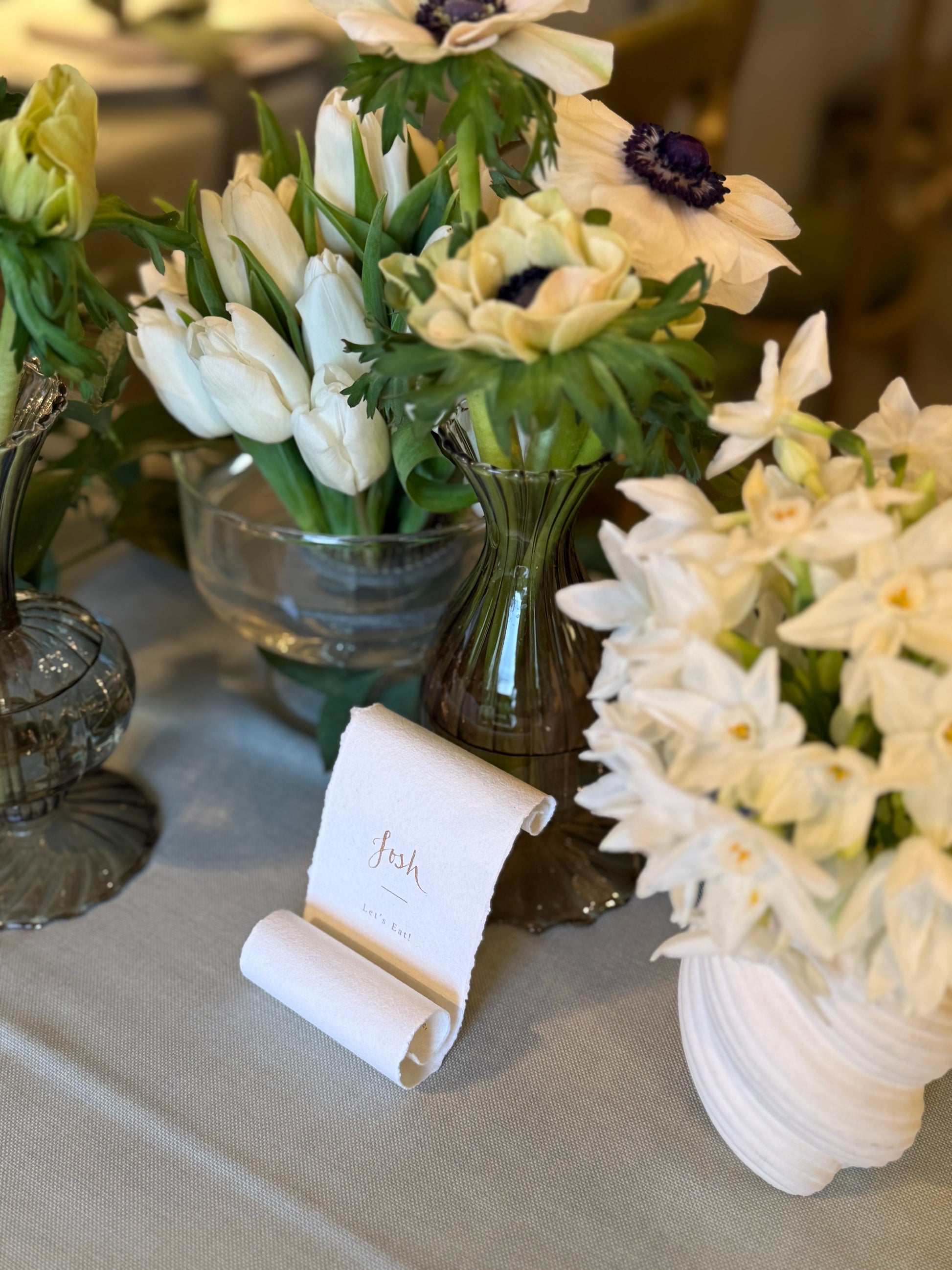 Decorative table setting with white flowers and a name card scroll with menu