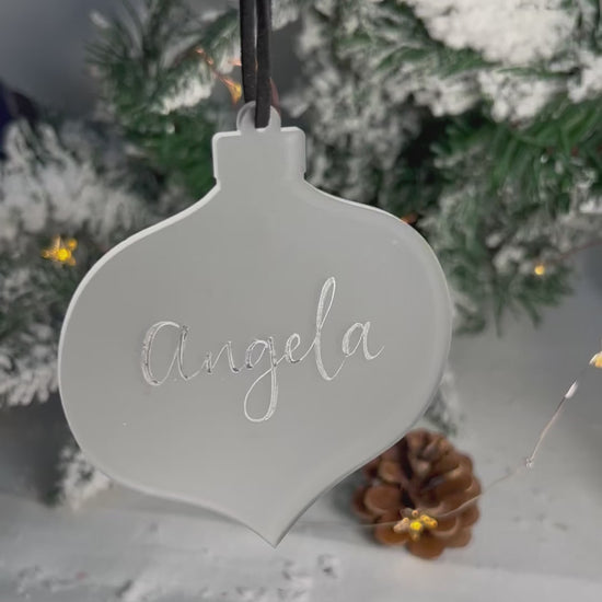 Video of hanging bauble handwritten name catching light 