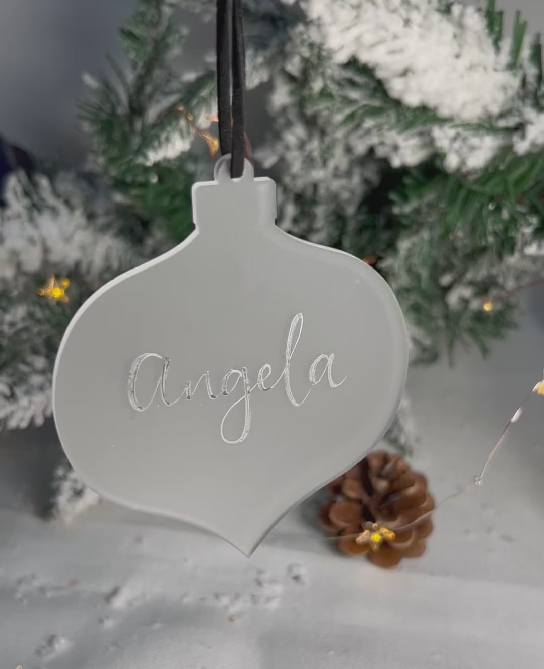 Video of hanging bauble handwritten name catching light 