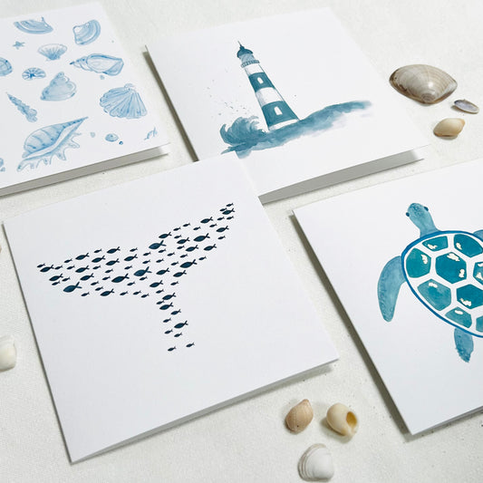 By the Sea collection of four cards featuring lighthouse, sea turtle, whale tail, fish, sea shells