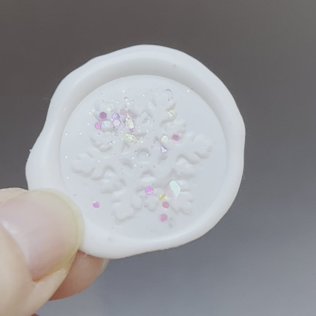 close up video of a snowflake wax seal with glitter