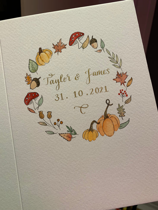 Bespoke autumn themed hand painted wedding card with pumpkins, leaves, mushrooms, toadstools and berries with gold ink calligraphy in middle