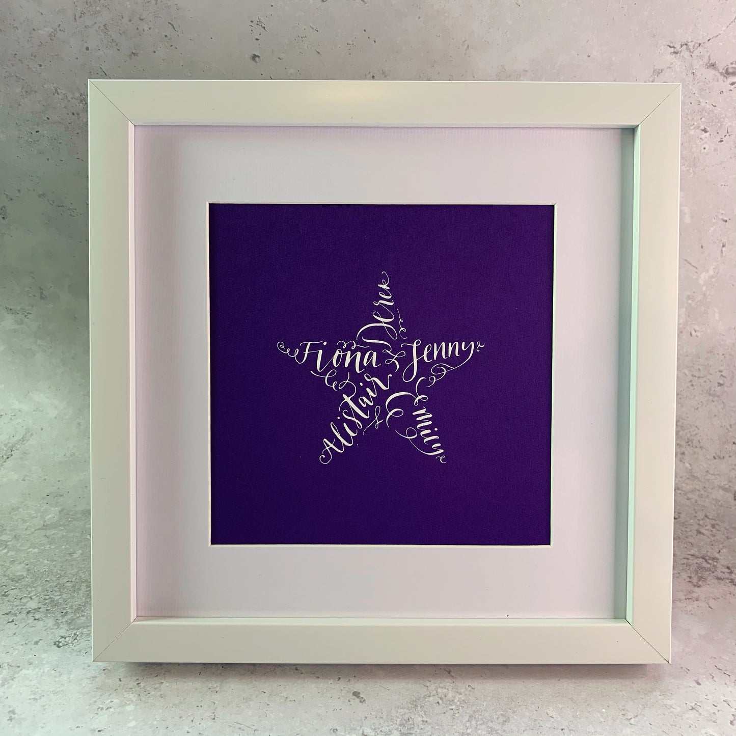 white square frame with white mount, purple card with white ink calligraphy names making star shape