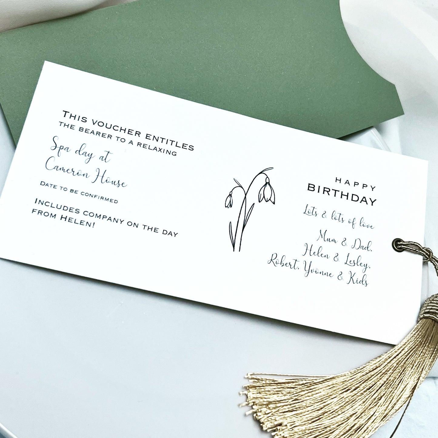 Long printed gift voucher with calligraphy and gold tassel, in green wallet