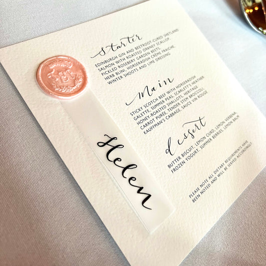 close up of menu including wax seal in pink and vellum name tag