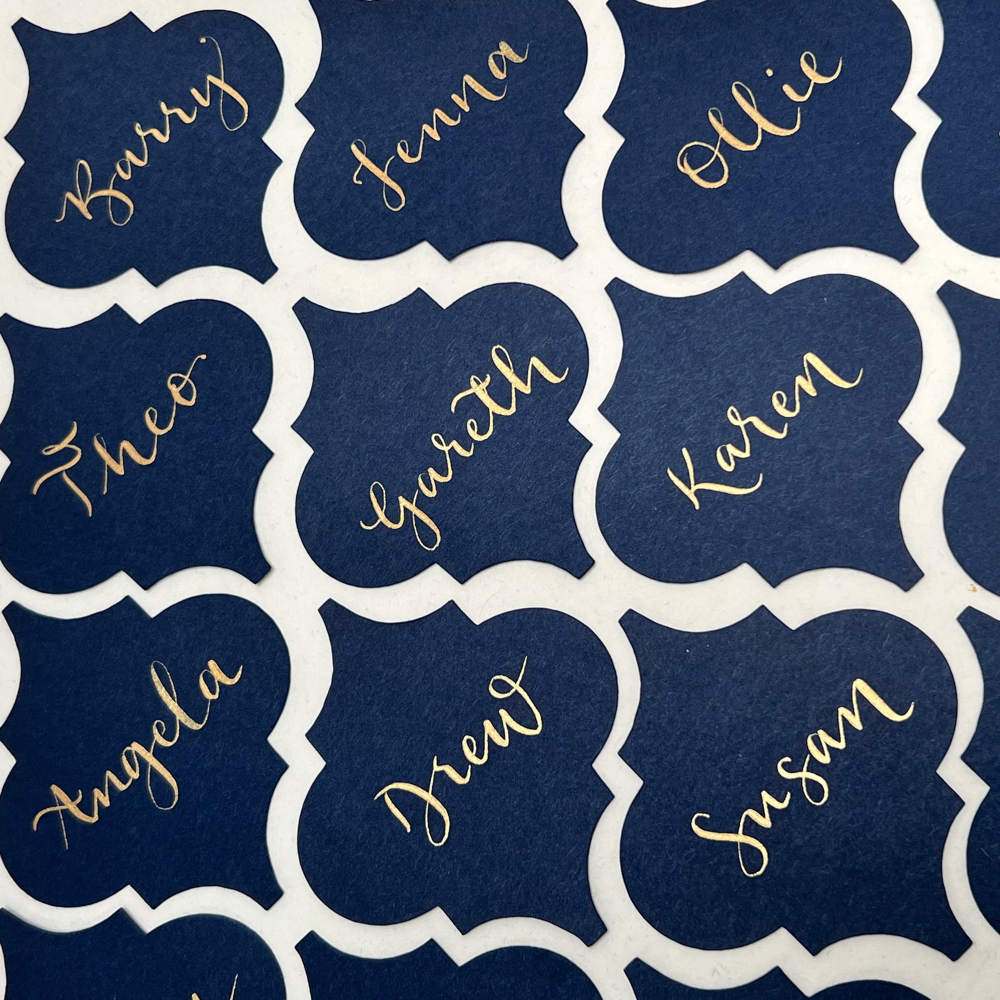 rows of moroccan tile shape cards with gold ink names 