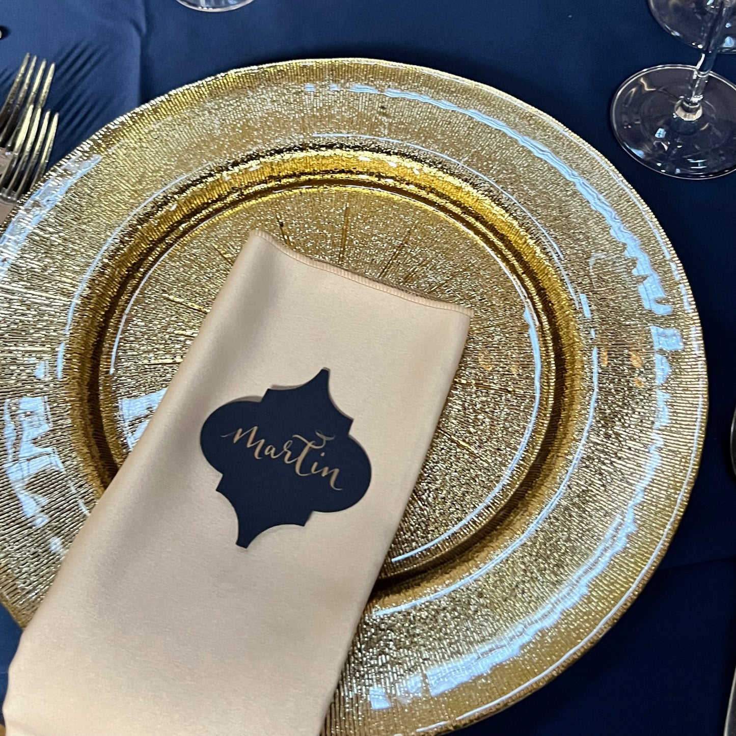 gold charger plate with ivory napkin, finished with navy moroccan tile shaped card with gold ink name - Martin