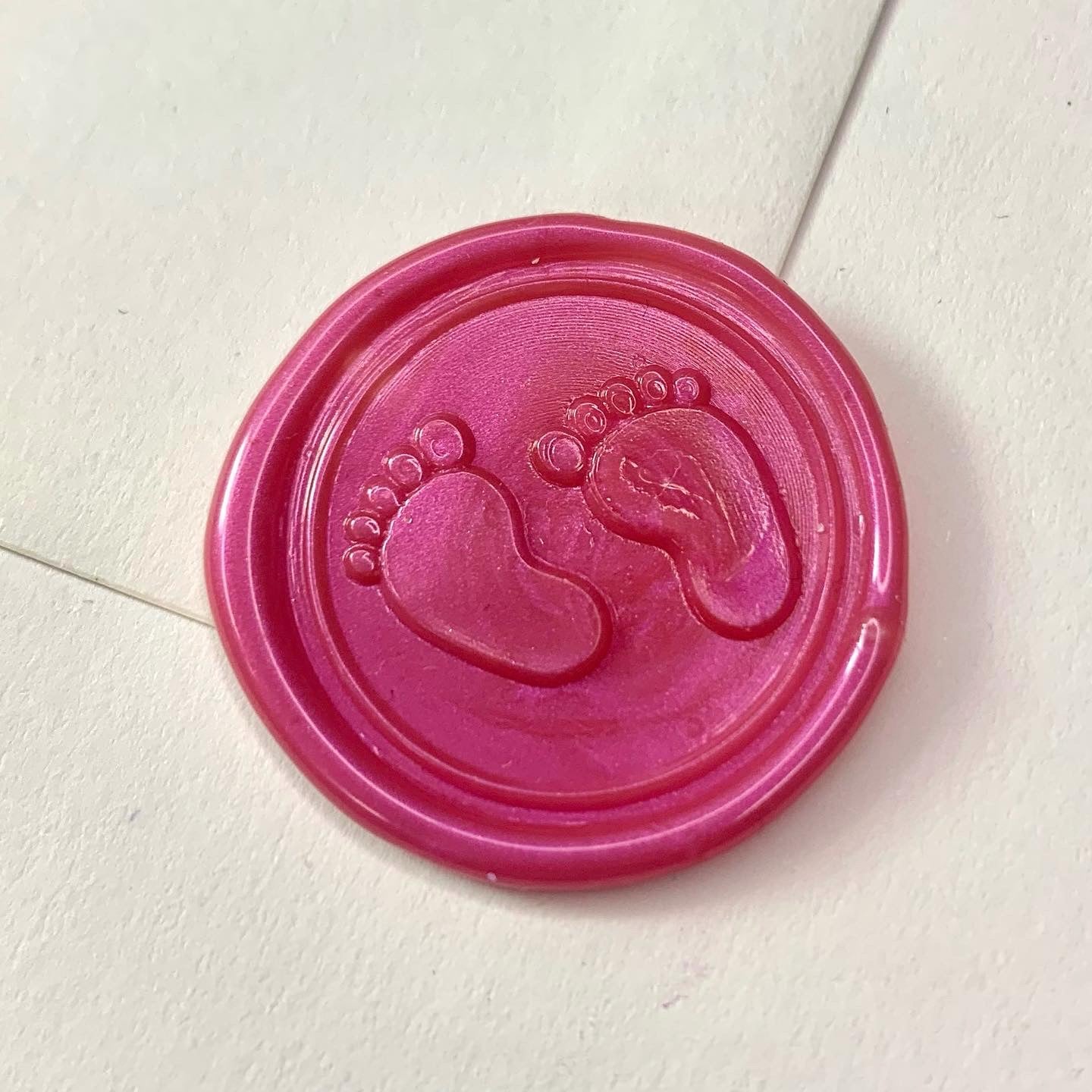 baby feet pink wax seal on white envelope