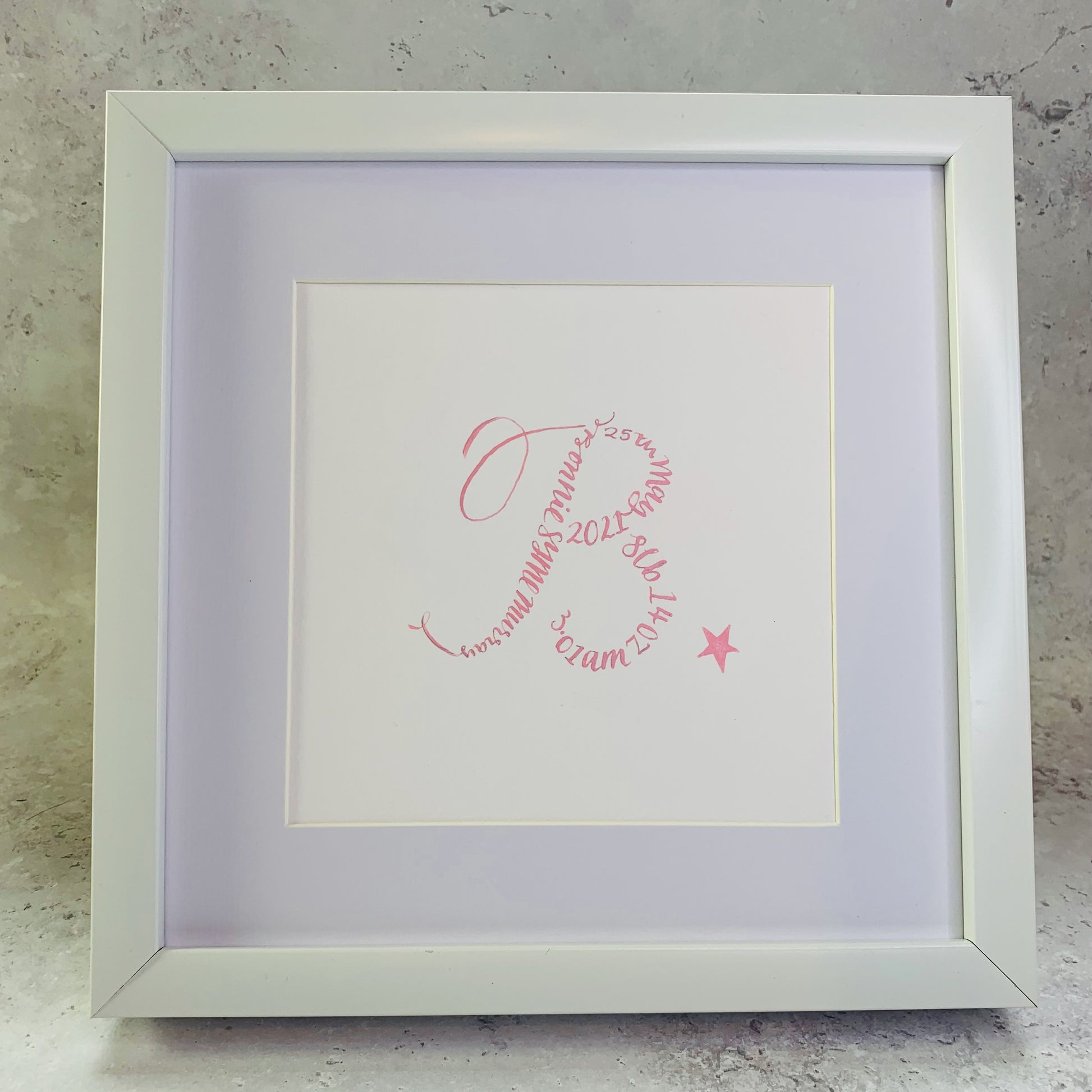 white square picture frame with white mount and white card. Letter B in pink calligraphy made up using name date of birth and weight of baby