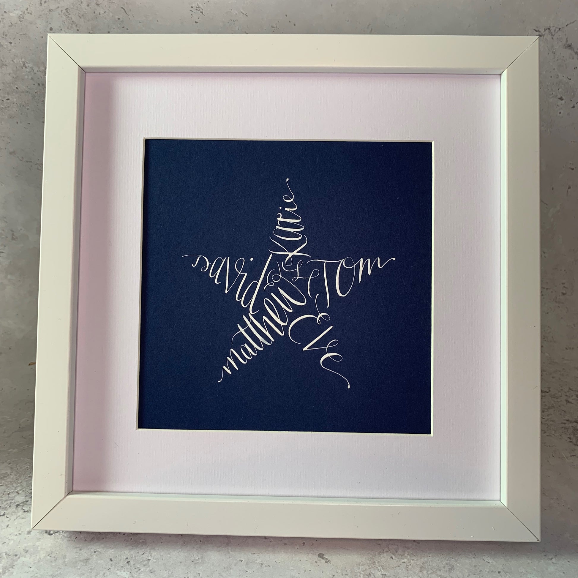 white frame and mount in square shape, navy card with white star calligraphy names