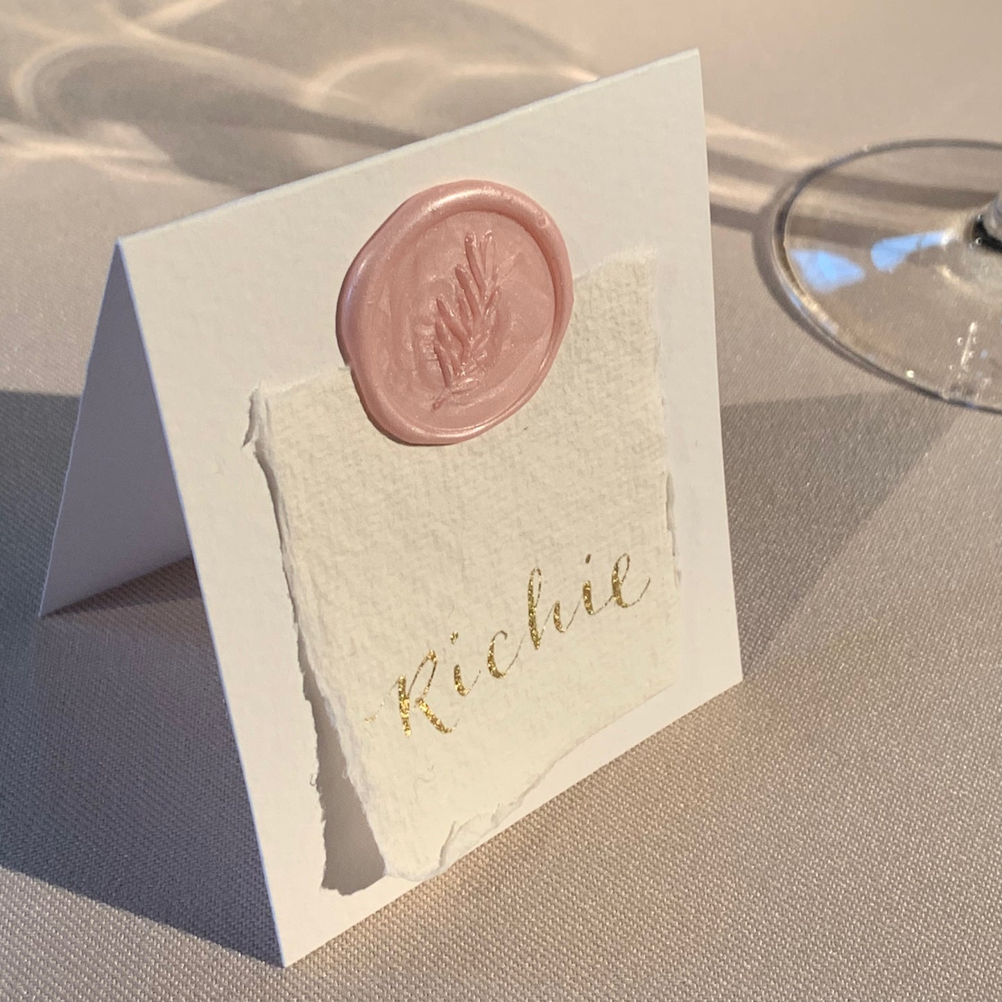 pale pink wax seal with foliage design, on place card 