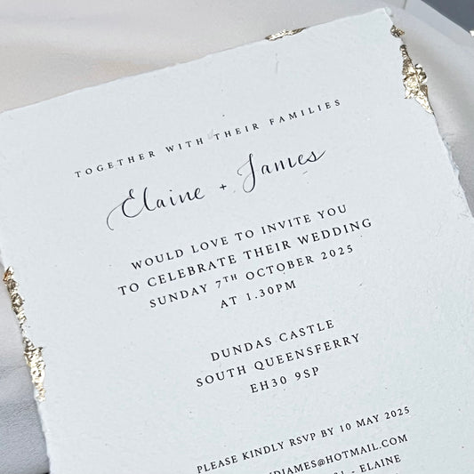 Close up of wedding invitation showing gold leaf flecks and soft cotton paper edges 