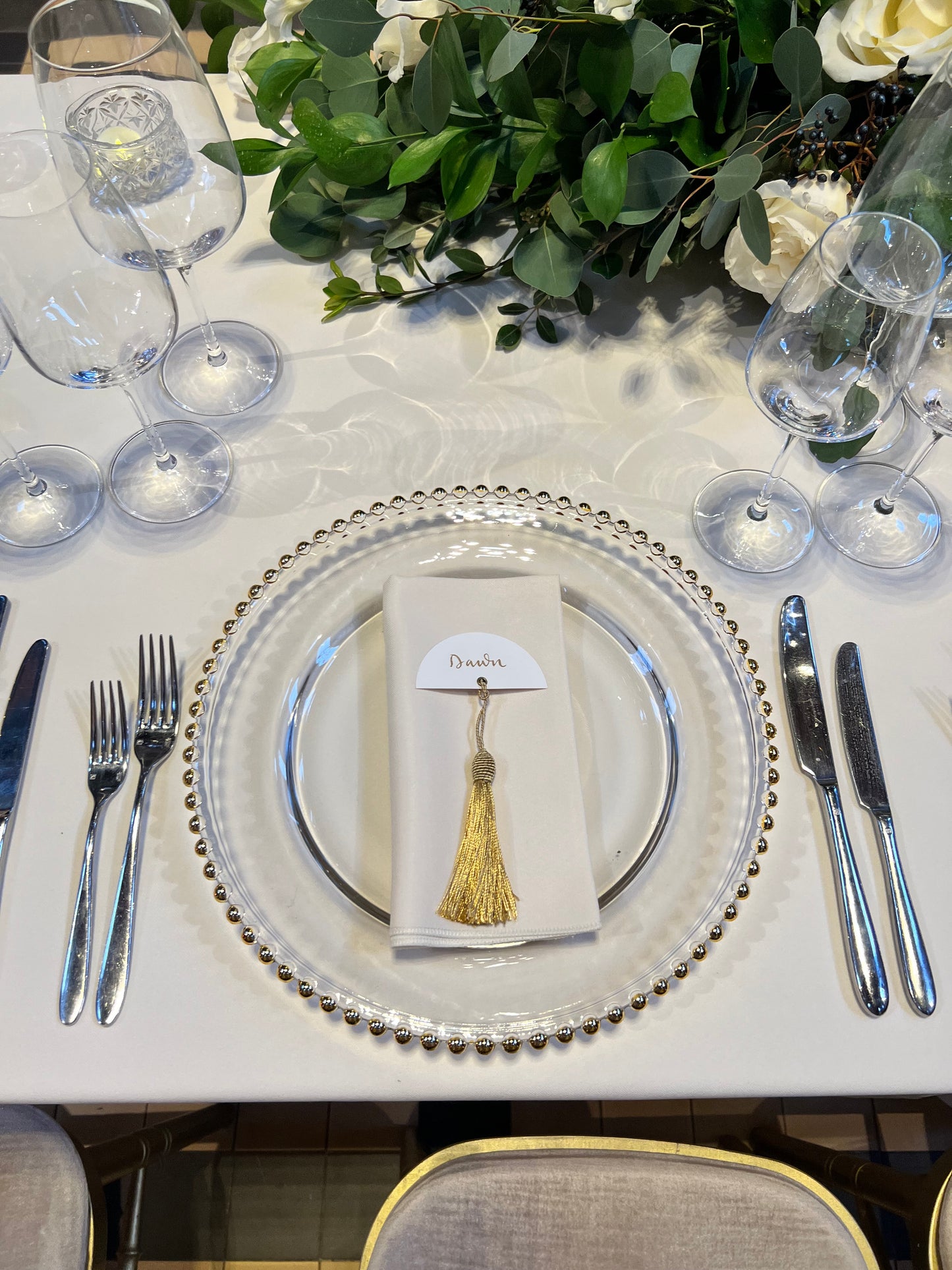 half circle place card on napkin, gold ink calligraphy and luxury gold tassel