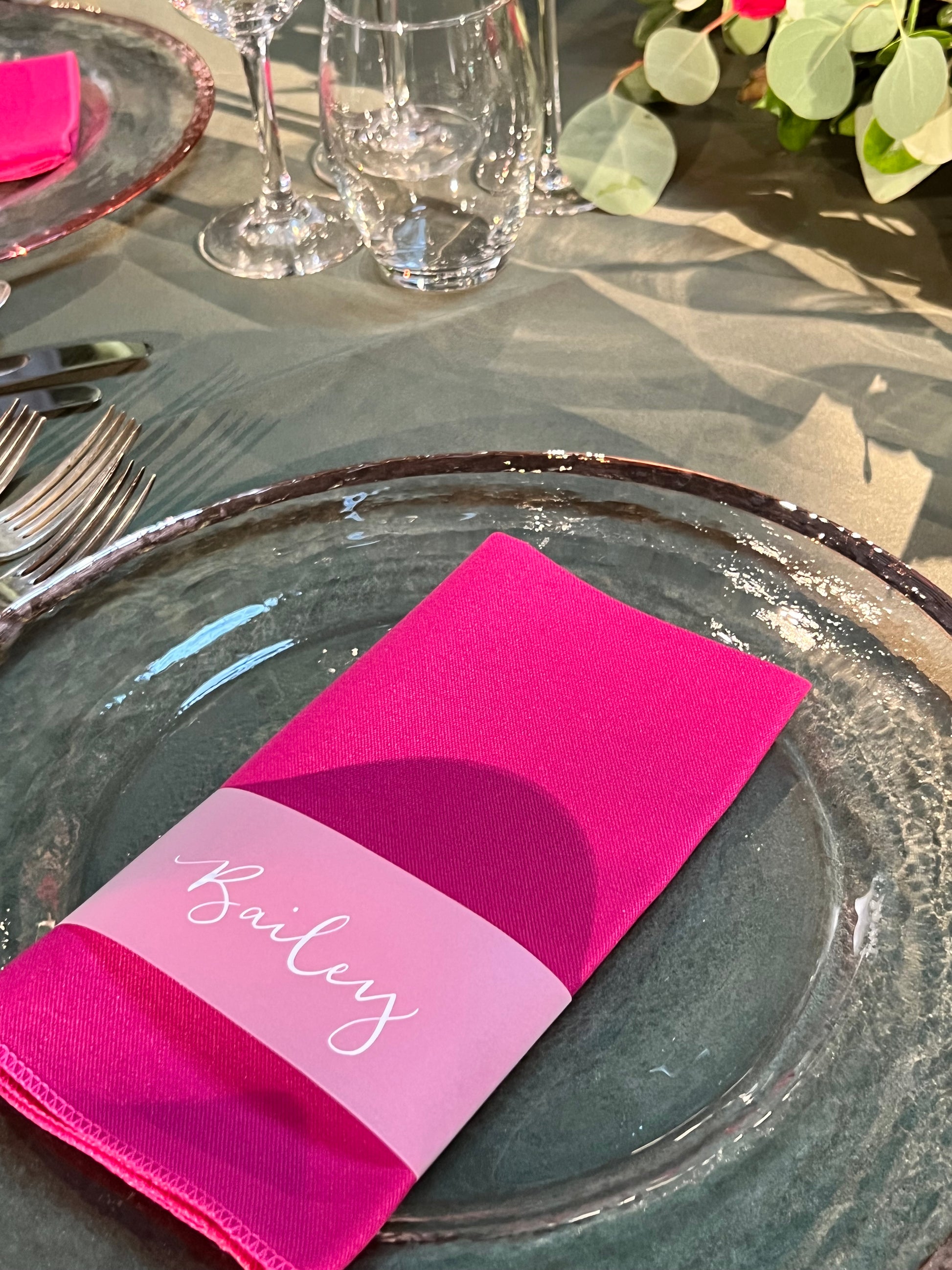 hot pink napkin with vellum paper cuff around napkin, white ink calligraphy guest name place card