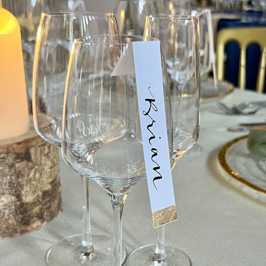gold leaf long wine glass guest name tag, with black ink calligraphy guest first name. black ink
